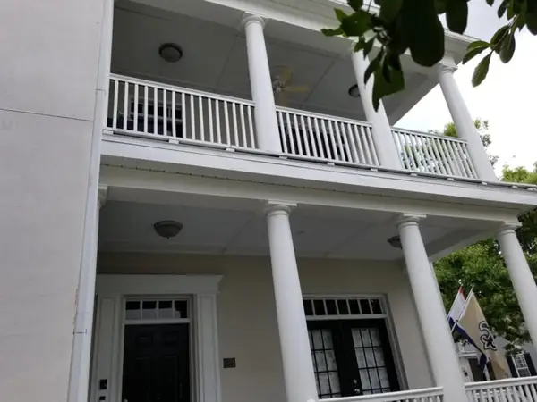 Two-story porch with freshly painted columns and railings