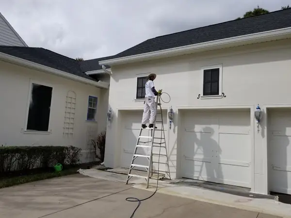 Spray painting a garage exterior