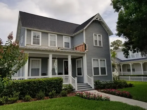 Damaged trim above a porch roof before repair