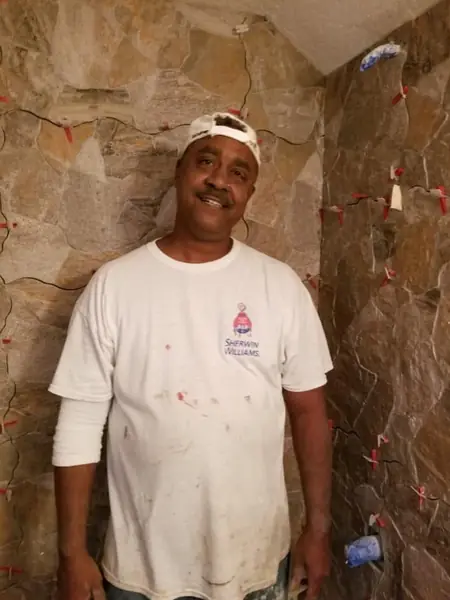 Owner Derwin Ferguson setting tile in a shower